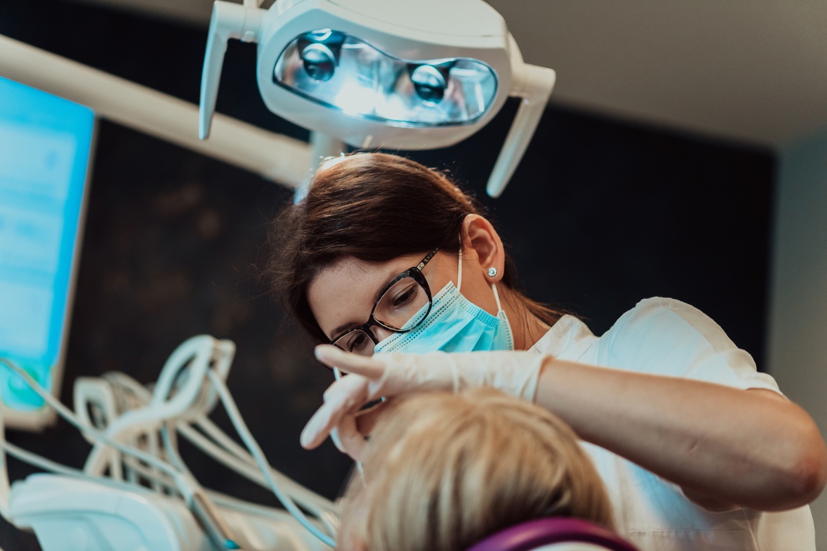 Dentist and dental assistant examining a young patient's teeth
