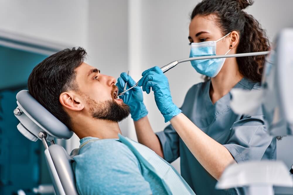 Dentist and assistant performing a dental procedure on a patient